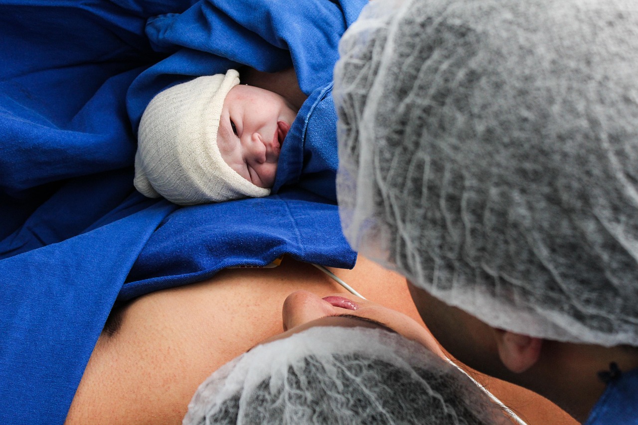 A photo of a couple looking at their newborn baby