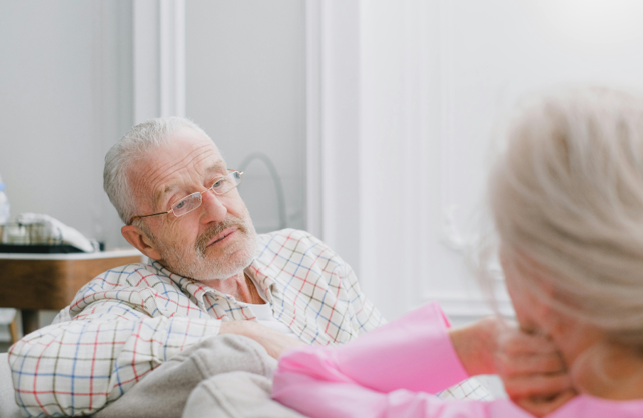 A man talking to another person on the sofa