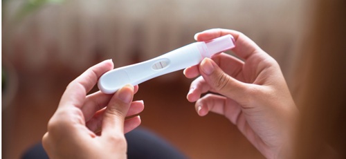 Hands holding a positive pregnancy test