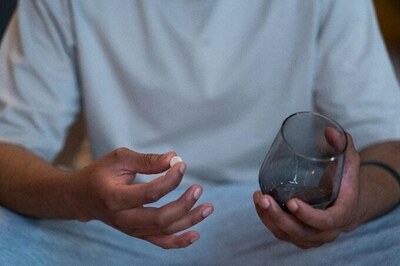 A person holding a tablet and glass of water.