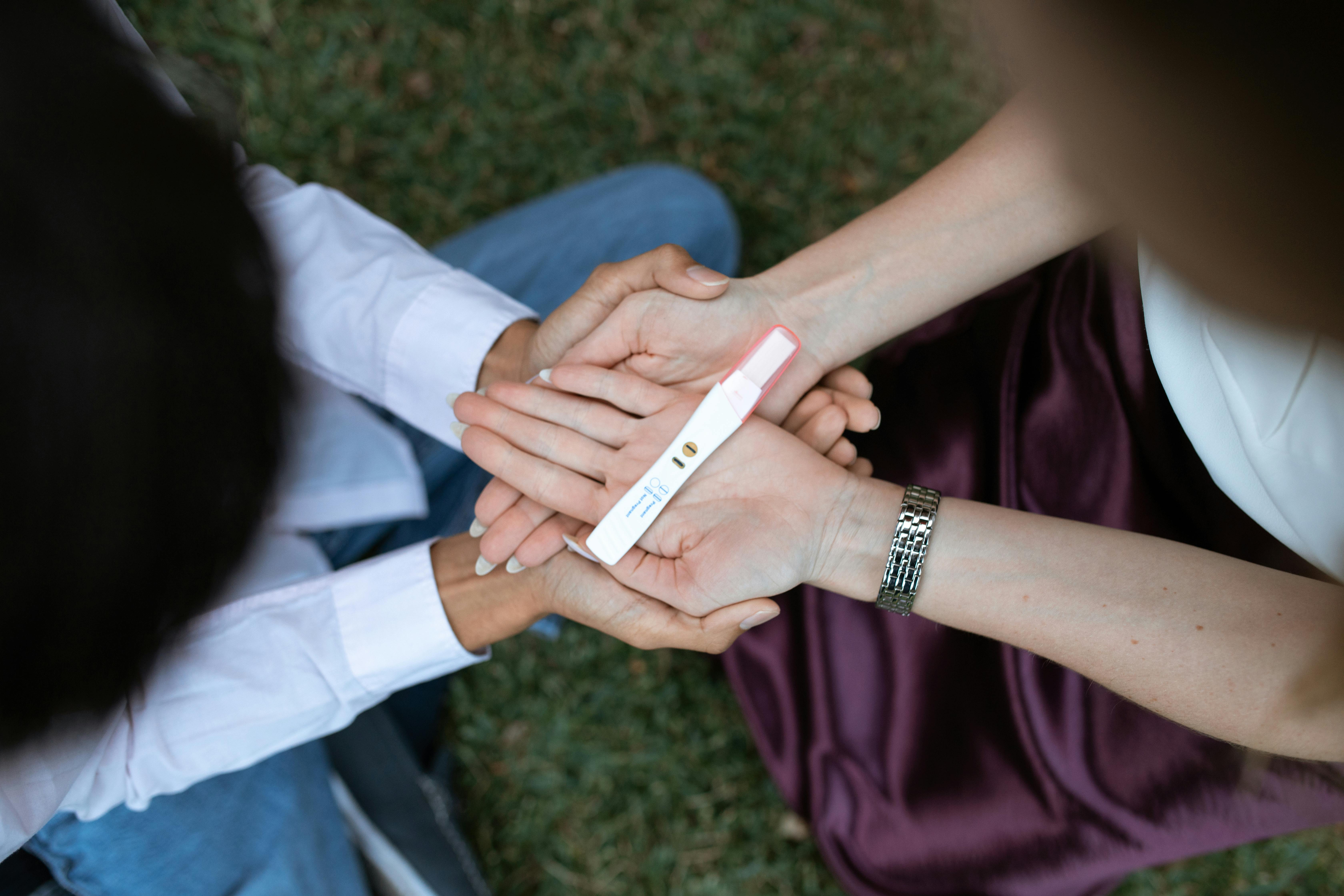Photo of a couple holding a pregnancy test stick.