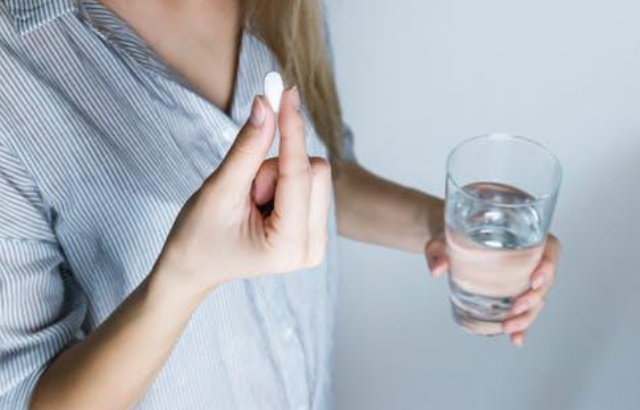 A picture of a person taking a tablet