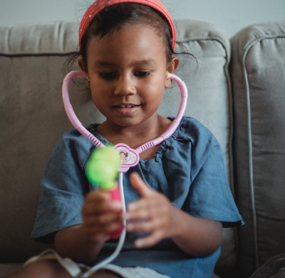 Picture of a young girl playing with a toy stethoscope.