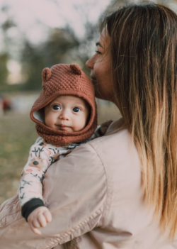 Picture of woman holding her baby in the park.