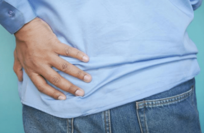 A photo of a person holding the side of their back.