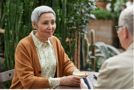 Two people talking outside over coffee