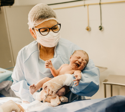 Picture of a nurse holding a baby born by caesarean.