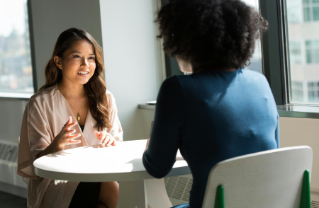 A photo of two women talking at a table